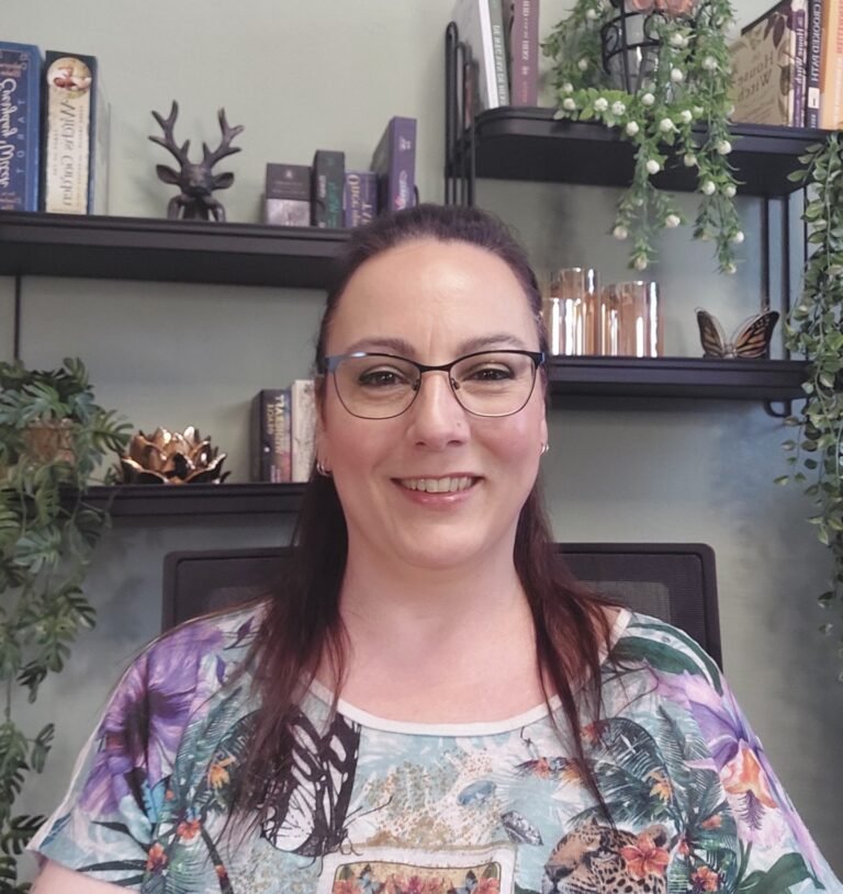 Diana Hokke die achter haar bureau zit met een gezellige back drop