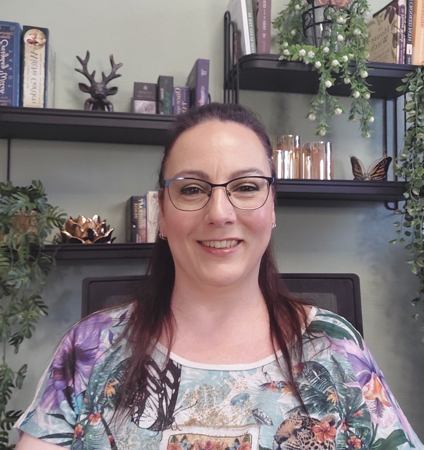 Diana Hokke die achter haar bureau zit met een gezellige back drop